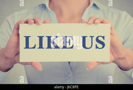 Closeup Geschäftsfrau Hände mit weißem Karton Schild mit wie wir SMS auf graue Wand Büro Hintergrund isoliert. Retro-Instagram Stil Bild Stockfoto