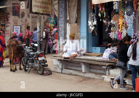 Eigentümer sitzt vor seinem Lebensmittelgeschäft in Pushkar, Rajasthan, Indien am 18. Februar 2016. Stockfoto