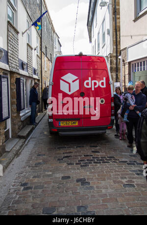 ST. IVES, CORNWALL, UK - 18. APRIL 2017. Ein roter Lieferwagen aus der Logistik Firma Dpd Pakete durch die schmale Straße von St. Ives. Stockfoto