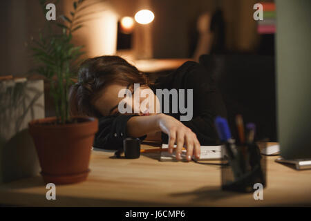 Junge Frau Designer schlafen am Arbeitsplatz im Büro Stockfoto