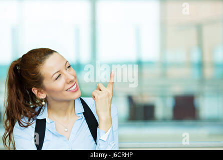 Closeup Portrait charmant lächelnd fröhlich glücklich Geschäftsfrau auf der Suche nach oben etwas träumen, denken mit Finger oben isoliert Hinterg Stockfoto