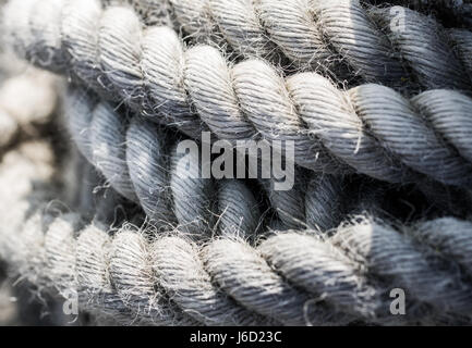 Eine Nahaufnahme, Hintergrundbild von Spulen von dicken, schweren Seil, das getragen ist, verwittert und ausgefranst und verwendet für Versand- und nautischen Themen. Stockfoto