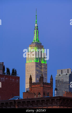 Das Empire State Building in der Dämmerung in grünes Licht beleuchtet. New York City (Blick aus der Highline in Chelsea) Stockfoto