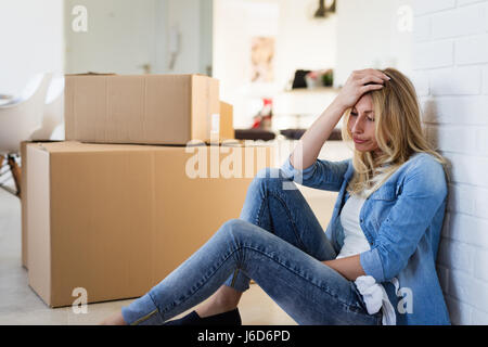 Müde Frau erschöpft beim Umzug in neues Zuhause Stockfoto