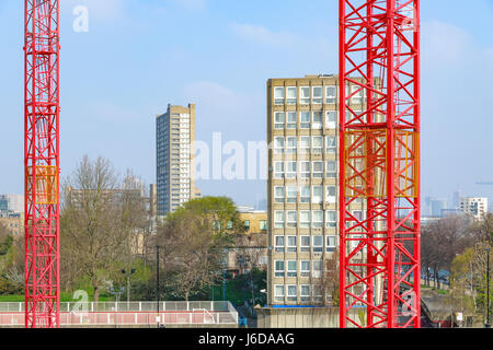 Rotes Gebäude Krane mit East London Sozialwohnungen Blöcke im Hintergrund Stockfoto