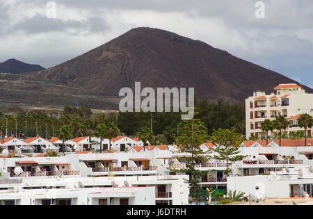 Die düsteren vulkanischen Berge und Hügel mit Blick auf Playa Las Americas und Los Christianos in Teneriffa auf den Kanarischen Inseln an einem langweiligen Tag Stockfoto