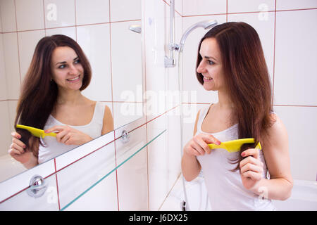 Junge Frau, Bürsten ihr Haar im Bad Stockfoto