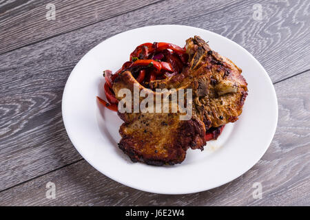 Pfanne gebratene Schweinekoteletts mit Paprika auf weißen Teller Stockfoto