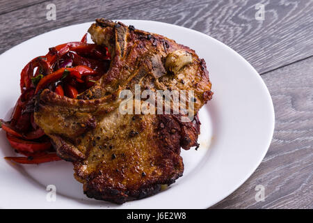 Pfanne gebratene Schweinekoteletts mit Paprika auf weißen Teller Stockfoto