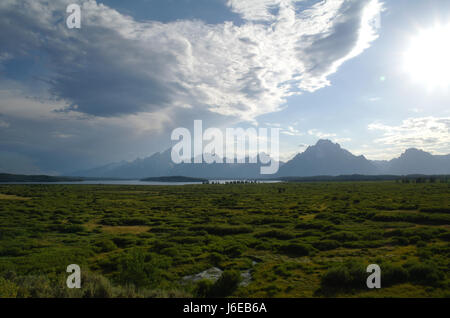 Blauer Himmel Stratocumulus Wolken sehen, südlich von Jackson Lake Lodge, der Teton Range mit weißen Strahlen der Sonne Sonne versinken über Biwak Peak, Wyoming, USA Stockfoto