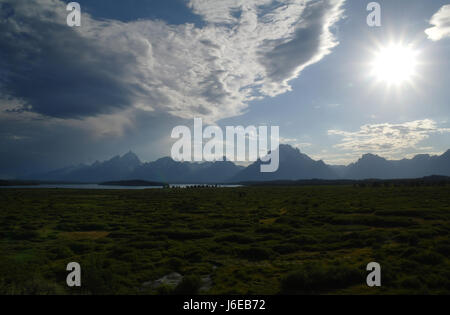 Blauer Himmel Stratocumulus Wolken anzeigen, südlich von Jackson Lake Lodge in Jackson Hole, weiße Sonne versinken über Teton Range Biwak Peak, Wyoming, USA Stockfoto