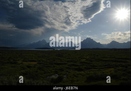 Blauer Himmel Stratocumulus Wolken über Jackson Hole in Richtung Teton Range und weiße Sonne versinken über Biwak Gipfel, südlich von Jackson Lake Lodge, Wyoming Stockfoto