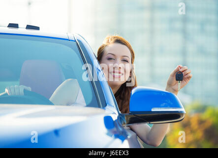 Closeup Portrait glücklich, Lächeln, junge attraktive Frau, Käufer sitzen in ihrem neuen blau Auto zeigen, Schlüssel isoliert außerhalb Händler, Autohaus viel offic Stockfoto