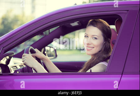 Porträt zu Lächeln, attraktive glückliche Frau, angeschnallt, fahren, testen ihr neues Auto violettes, Automobil, Autohaus, isolierte Straße, Stadt gekauft Stockfoto