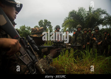 U.S. Marine Corps Lance Cpl. Anthony Espinal, ganz links, und Lance Cpl. Nigel Lyons, beide Gewehrschützen mit 2. Bataillon, 4. Marine Regiment, demonstrieren, Royal Thai Marines der Lage, während der Landung Kraft Zusammenarbeit flott Bereitschaft und Training (LF Karat) 2015 auf amphibischen Angriff Base, Phlutaluang, Thailand, 28. August 2015 sichern. LF-Karat soll Stärkung und zur Steigerung der Interoperabilität bei der amphibischen Planung und Operationen und die Kernkompetenz setzt zwischen den Vereinigten Staaten und die Nationen von Indonesien, Malaysia und Thailand. (U.S. Marine Corps Foto von MCIPAC kam zu bekämpfen Stockfoto