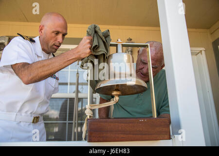 Lt. CMdR David Jeltema, Kaplan mit Naval Medical Center San Diego, präsentiert die Quarterdeck Glocke von der USS Black Hawk (AD-9), Herbert Crask, ein Marine-Veteran in Trinidad, Colorado 9. August 2016. Während seiner 10-jährigen Eintragung Crask serviert an Bord der USS Black Hawk, der USS West Virginia (BB-48) und die USS Prairie (AD-15). Stockfoto