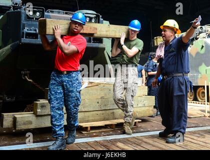 160820-N-TI017-106 Golf von ADEN (20. August 2016) Boatswain Mate 2. Klasse Jeffrey Ronchaquira leitet ein Matrose und eine Marine mit Verbau im Brunnen Deck von der Amphibien dock Landungsschiff USS Whidbey Island (LSD-41). Whidbey Island ist mit der Wespe amphibische bereit Gruppe zur Unterstützung von maritimer Sicherheitsoperationen und Sicherheitsbemühungen Zusammenarbeit Theater in den USA bereitgestellt 5. Flotte Einsatzgebiet. (Foto: U.S. Navy Mass Communication Specialist 2. Klasse Nathan R. McDonald/freigegeben) Stockfoto