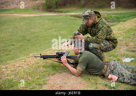 Ein US-Marine mit Waffen Training Bataillon (WTBn) löscht das M16A4 Gewehr eines Space-Marines mit The Basic School (TBS) beim Montford Point Biathlon am WTBn, Marine Corps Base Quantico, VA., 7. April 2017. Während des zweiten Weltkriegs Präsident Roosevelt ausgezeichnet Afro-Amerikaner die Möglichkeit, in der Marine Corps rekrutiert werden und zur Verfügung gestellt Grundausbildung bei Montford Point Camp in North Carolina. Diese jährliche Veranstaltung findet für TBS Marines zu Ehren die Härten von Montford Point Marines durch den Wettbewerb auf einem 6,5 Meilen Kurs, in dem Vierer-Teams von TBS Waffen Training Bataillon laufen konfrontiert, Stockfoto