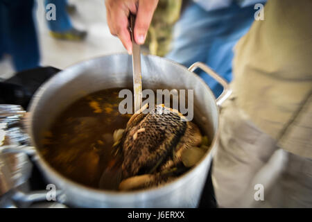 Kopf Fischsuppe ist bis 6. Special Operations Squadron combat Aviation Berater Studenten während der Operation Raven Klaue am Duke Field, Florida, 26. April 2017 serviert. Schüler gemeinsam mit ihren Partnern eine Mahlzeit, die einen Luxus im "Palmetto Land" Kultur, Beziehungen zu stärken gilt. (Foto: U.S. Air Force Airman 1st Class Joseph Pick) Stockfoto