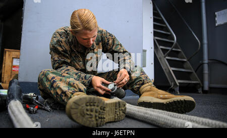 Pazifischen Ozean – Lance Cpl. Caitlin McCoy, eine Landung-Support-Spezialist mit bekämpfen Logistik-Bataillon 15, der Logistik zu bekämpfen Bestandteil der 15. Marine Expeditionary Unit, macht Anpassungen an Seilen für eine bevorstehende Hubschrauber Team Training-Betrieb unterstützen wo zwei M777 Haubitzen transportiert werden von Ship-to-Shore während zusammengesetzte Einheit Übung, 2. Mai 2017. CLB-15 unterstützt die Marine Air-Ground Task Force durch eine Vielzahl von logistischen Nahrung wie Wasseraufbereitung, allgemeiner Maschinenbau und eine robuste medizinische Funktion. COMPTUEX ist das zweite auf See Ausbildung e Stockfoto