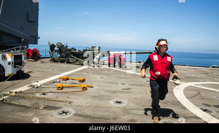 Pazifischen Ozean – Lance Cpl. Caitlin McCoy, eine Landung-Support-Spezialist mit bekämpfen Logistik-Bataillon 15, der Logistik zu bekämpfen Bestandteil der 15. Marine Expeditionary Unit Unterstützung läuft an ihre gewünschte Position vor der Durchführung eines Hubschraubers Team Betrieb wo zwei M-777 Haubitzen während zusammengesetzte Einheit Übung, 3. Mai 2017 ans Ufer transportiert werden. COMPTUEX testet die LCE-Fähigkeit, Personal und Ausrüstung vom Meer in Richtung land demonstriert die amphibische Kraft umfangreichen Satz von Ship-to-Shore-Fähigkeiten zu bewegen.  COMPTUEX ist die zweite auf See-Übung, die bietet Stockfoto