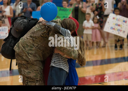 Eine Familie umarmt während der Homecoming von 92 Fliegern der 554th RED HORSE Squadron und zwei Fliegern der 36th Civil Engineer Squadron auf der Andersen Air Force Base, Guam. Diese Airmen wurden nach Südwestasien eingesetzt, um schwere Baukapazitäten in der Region zu bieten. Stockfoto