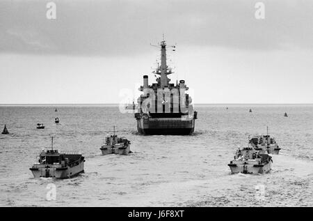 AJAXNETPHOTO. 6. APRIL 1982. PORTSMOUTH, ENGLAND. -HMS FEARLESS VERLÄSST PORTSMOUTH FÜR DEN FALKLAND-INSELN, GEFOLGT VON IHRER FLOTTILLE LANDUNGSBOOTE. FOTO: JONATHAN EASTLAND/AJAX REF: 820604 5 Stockfoto