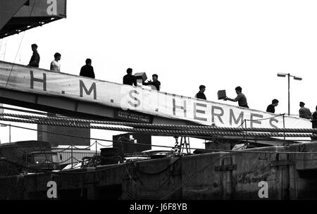 AJAXNETPHOTO. 3. APRIL1982. PORTSMOUTH, ENGLAND - FALKLAND INSELN ABFAHRT. HMS HERMES LASTEN STORES AS BEREITET SIE SEGEL FÜR DEN SÜDATLANTIK. FOTO: JONATHAN EASTLAND/AJAX REF: 820304 2 Stockfoto