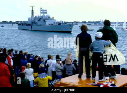 AJAXNETPHOTO. 19. JUNI. 1982. PORTSMOUTH, ENGLAND. -RENDITE SURVIVOR - DER TYP 42 (1 & 2) SHEFFIELD KLASSE ZERSTÖRER (3660 TONNEN) HMS GLASGOW, EIN PATCH IN IHREM RUMPF SICHTBAR, WO EINE ARGENTINISCHE BOMBE EINGETRAGEN AM RUMPF, KEHRT NACH HAUSE ZURÜCK ZU MASSEN VON GÖNNERN VERSAMMELTEN SICH AM BRUNNEN SEE STEG.  FOTO: JONATHAN EASTLAND/AJAX. REF: 910168 Stockfoto