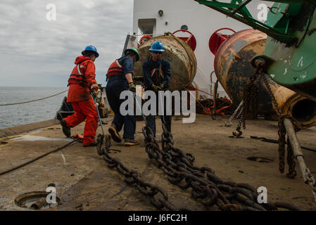 Coast Guard Cutter Oak Besatzungsmitglieder Seemann Samantha Schwind, Seaman Joseph Alire und Matrose Matthew Perez Kette Haken verwenden ziehen Sie Kette über dem Fräser Deck während der Durchführung von Wartungsarbeiten an einer Boje an der Küste von Massachusetts, Mittwoch, 10. Mai 2017. Coast Guard Cutter Oak ist ein 225-Fuß Boje zart Gridley in Newport, Rhode Island. (US Coast Guard Foto von Petty Officer Andrew Barresi) Stockfoto