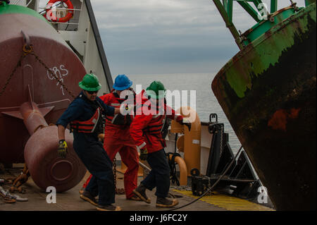 Coast Guard Cutter Oak Besatzungsmitglieder bewegen Weg von einer Boje nach dem Anbringen eines Hakens verwendet, um es auf das Deck des Schiffes, Mittwoch, 10. Mai 2017, vor der Küste von Massachusetts ziehen. Coast Guard Cutter Oak ist ein 225-Fuß Boje zart Gridley in Newport, Rhode Island. (US Coast Guard Foto von Petty Officer Andrew Barresi) Stockfoto