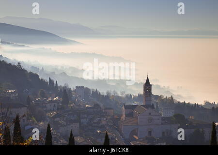 Schöne Aussicht auf die Kirche von St. Clare in Assisi (Italien) mit Nebel unten und im Hintergrund Stockfoto