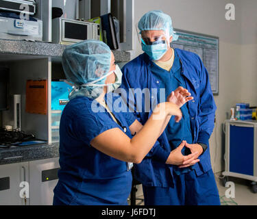 US Air Force Airman 1.Klasse, Dezina Khosroabadi mit der 60. chirurgische Operations Squadron, Travis Air Force Base in Kalifornien, erklärt ihre Pflichten Chief Master Sgt. Steve Nichols, 60. Air Mobility Wing Befehl Chef, während der Arbeiten mit Flieger Programm, 12. Mai 2017. Das Programm beinhaltet Flügel Führung Interaktion mit Flieger zu bekommen einen detaillierten Überblick über jede Mission an Travis durchgeführt. (U.S. Air Force Photo/Louis Briscese) Stockfoto