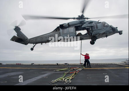 Sailors and Marines an Bord der USS America (LHA 6) befestigten am 12. Mai 2017 eine MH-60 Seahawk an das Flugdeck während einer Composite Training Unit Übung vor der Küste Südkaliforniens, als Teil der America Amphibious Ready Group und der 15th Marine Expeditionary Unit Trainingseinheiten. Stockfoto