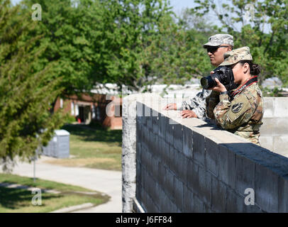 SPC. Roy Lopez mit der 206. Broadcast Operations Ablösung und Pvt. Justine Gutierrez mit dem 205. Press Camp Sitz beobachten und Fotografieren von Indiana National Guard Soldaten im Muscatatuck Urban Training Center am 13. Mai als Teil der US Army Reserve Public Affairs News Ausübungstag. (US Army Reserve Foto von Sgt. Clinton Massey, 206. Broadcast Operations-Abteilung) Stockfoto