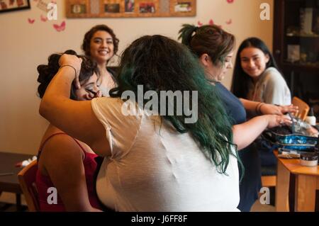 Erika Savedra und Samantha Aguilar (hinten) und Erin Flores (links) Senioren von Clover Park High School montieren in der Wohnung des Spc. Natasha Manning-Redmond, Kaplan Assistent und militärische Schwesternschaft Mitglied, ihr Haar und Make-up für Abschlussball 13. Mai 2017, auf Joint Base Lewis-McChord, Washington getan zu haben. Manning-Redmond mit Hilfe ihrer Schwestern der Schwesternschaft, behandelt die Schüler zu einem Spa und Kosmetikerinnen zur Vorbereitung für den Abschlussball geliefert.  (Foto: US-Armee Sgt. Youtoy Martin, 5. Mobile Public Affairs-Abteilung) Stockfoto