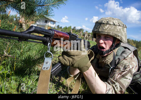 Ukrainische Soldaten mit dem 1. Airmobile Bataillon, ruft 79. Air Assault Brigade einen Kameraden, der andere Soldat weiß, dass er eingestellt und bereit, seine Bewegung während Paare Bewegungstraining am Yavoriv Combat Training Center auf der internationalen Friedenssicherung und Security Center in der Nähe von Yavoriv, Ukraine, am 15. Mai zu decken zu lassen.     Yavoriv CTC-Personal zusammen mit Mentoren aus der US-Armee 45. Infantry Brigade Combat Team, führte Paare Bewegungstraining für Soldaten von der 1-79. während der Rotation des Bataillons durch Yavoriv CTC. 45. bereitgestellt wird, in die Ukraine als Teil der Stockfoto