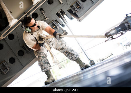 Ein Flieger von der 41. Hubschrauber-Wartungseinheit führt ein Seil ziehen ein HH - 60G Pave Hawk in einer c-17 Globemaster III, 15. Mai 2017, Moody Air Force Base, Ga.  Laden den Hubschrauber für Transport, war der erste Schritt in eine Rapid-Rettungs-Übung durchgeführt an Langley AFB, VA., die entworfen wurde, testen Sie die Betreuer und Flugpersonal der Fähigkeit, schnell einzurichten und durchzuführen Rettungsaktionen von ihrer Heimat entfernt. (Foto: U.S. Air Force Staff Sgt Ryan Callaghan) Stockfoto