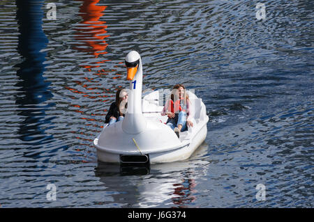 Die Menschen genießen heißen Tag in Swan Tretboote am Fluss Lea im Queen Elizabeth Olympic Park, London England United Kingdom UK Stockfoto