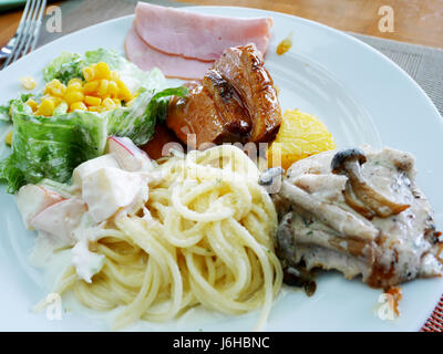 Spaghetti, Salat, Seatk und Schinken auf Teller zu Essen am buffet im Restaurant des Hotels in Thailand Stockfoto