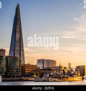 HMS Belfast (ein Museum Schiff) auf der Themse mit The Shard Wolkenkratzer (ehemals London Bridge Tower) auf der linken Seite. Stockfoto