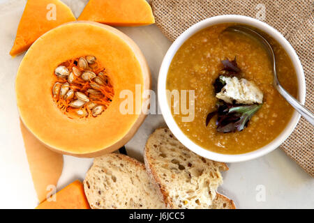 Kürbissuppe mit Brotscheiben und Kürbis. Stockfoto