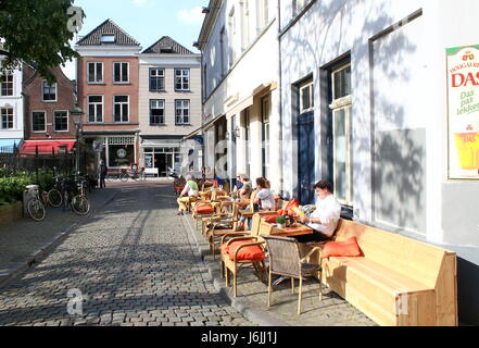 Menschen genießen die Frühlingssonne auf einer Terrasse an der Sint Janskerkhof Street (in der Nähe von St. Johns Cathedral) im Zentrum von Den Bosch, Niederlande Stockfoto