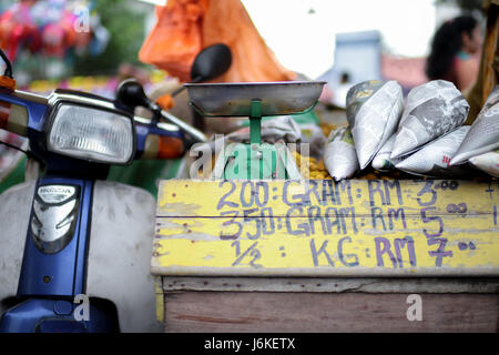 Hawker auf Motorrad Verkauf gekochte Erdnuß in Zeitungspapier eingewickelt. Stockfoto