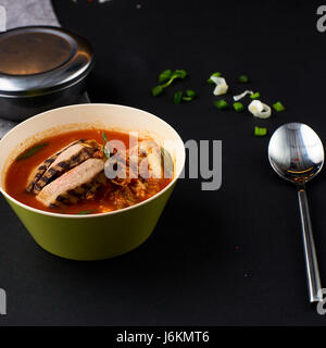 Koreanische Küche. Kimchi-Suppe auf schwarzem Hintergrund. Stockfoto