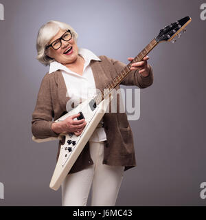 Glücklich lustig senior Frau spielt e-Gitarre Stockfoto