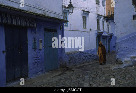 18.11.2010, Tanger, Marokko, Afrika - ein Mann geht durch das Labyrinth der Gassen und vorbei an blau-weißen Häuserfassaden in der Medina. Stockfoto