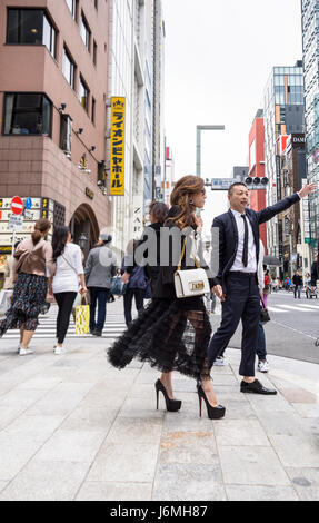 Ein junges japanisches Paar im trendigen Viertel Ginza, Tokio, ruft ein Taxi. Modebewusstes, modernes junges Paar. Stockfoto