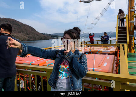 Junge asiatische Mädchen nehmen ein Selbstporträt auf eine Replik Piraten Schiff. Stockfoto