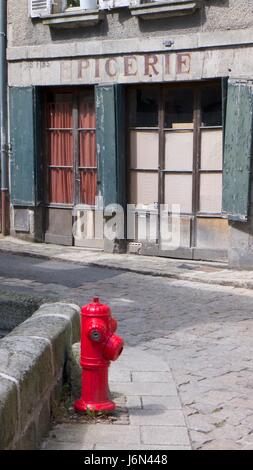 Red Fire Hydrant auf gepflasterten Straße, Aubusson, Cruese, Frankreich Stockfoto